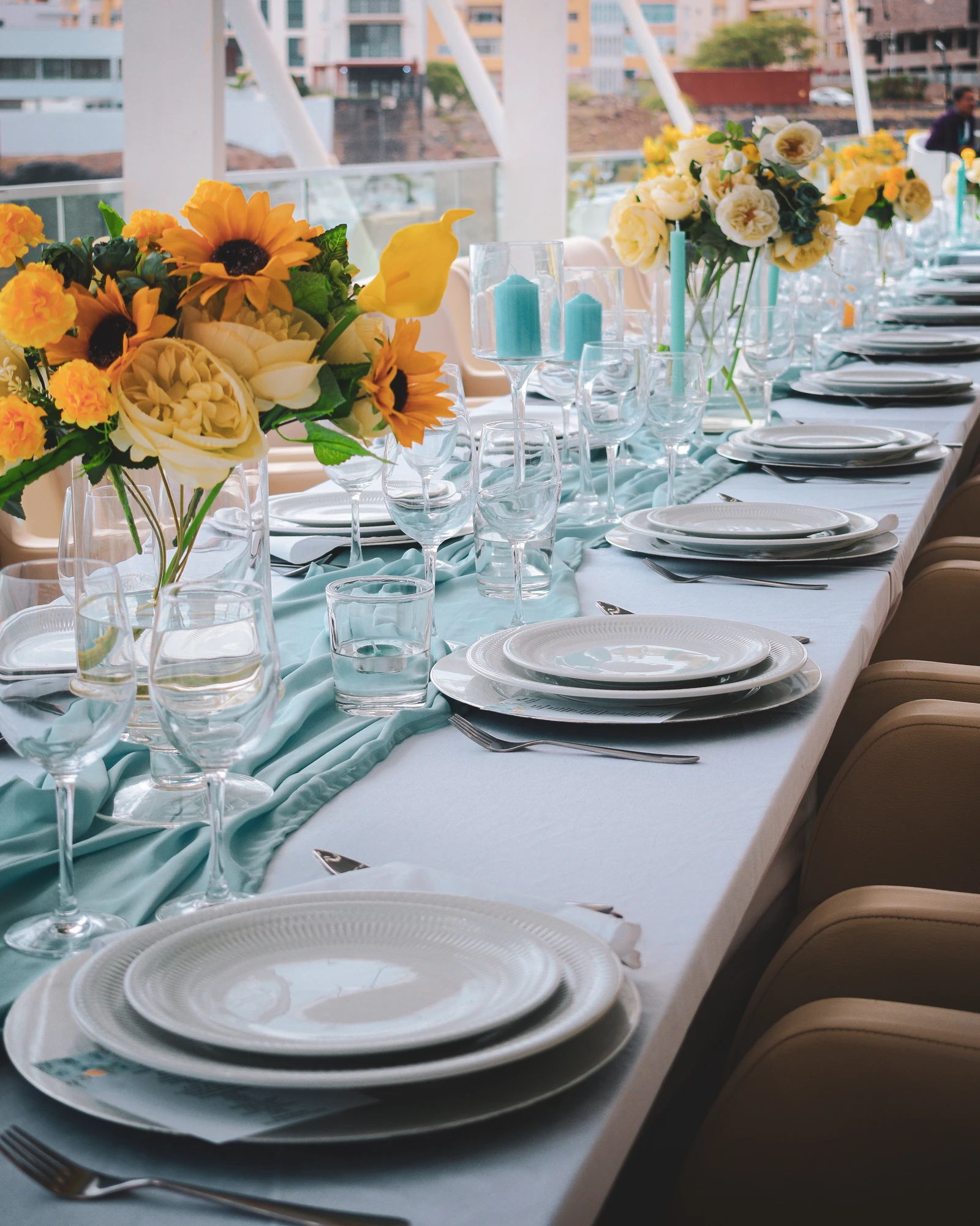 Mesa de evento preparada com flores amarelas.